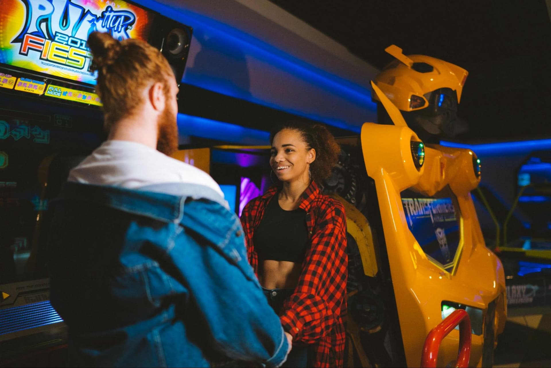 a man and a woman holding hands in an arcade