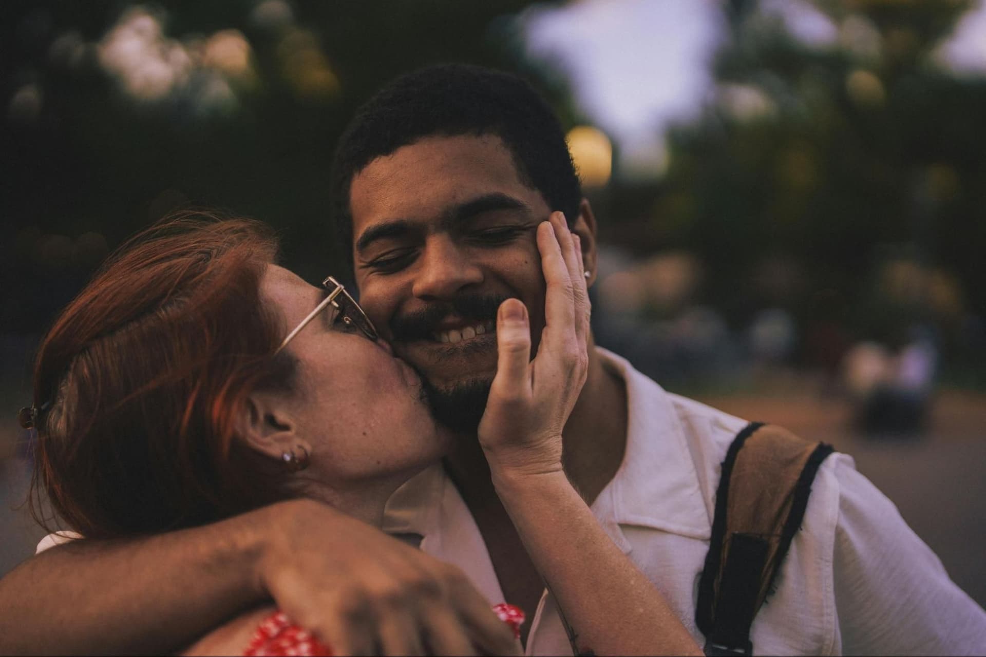 A woman kissing a man on the cheek