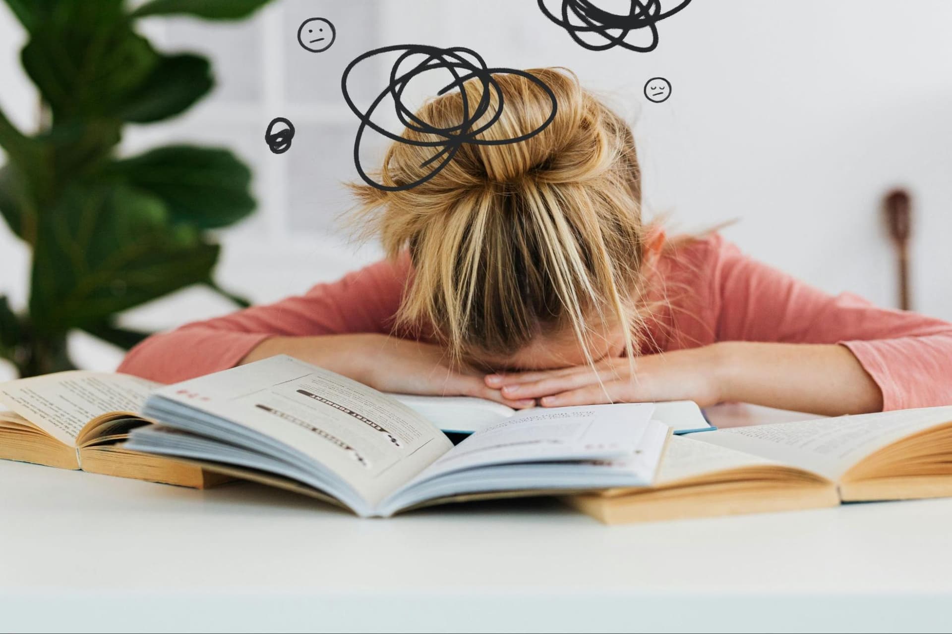 A girl lays her head on a pile of books, with doodled scribbles above her head indicating she is tired or overwhelmed
