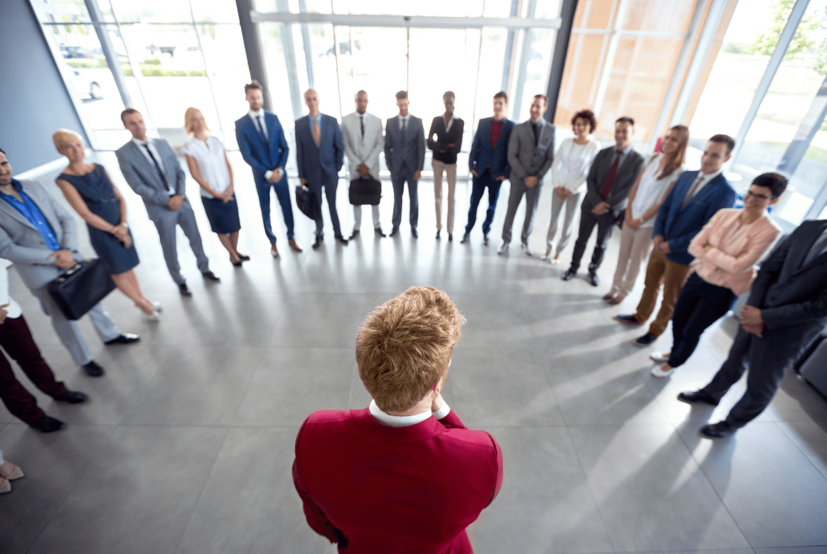 A man standing in front of a group of people in a business setting, representing leadership
