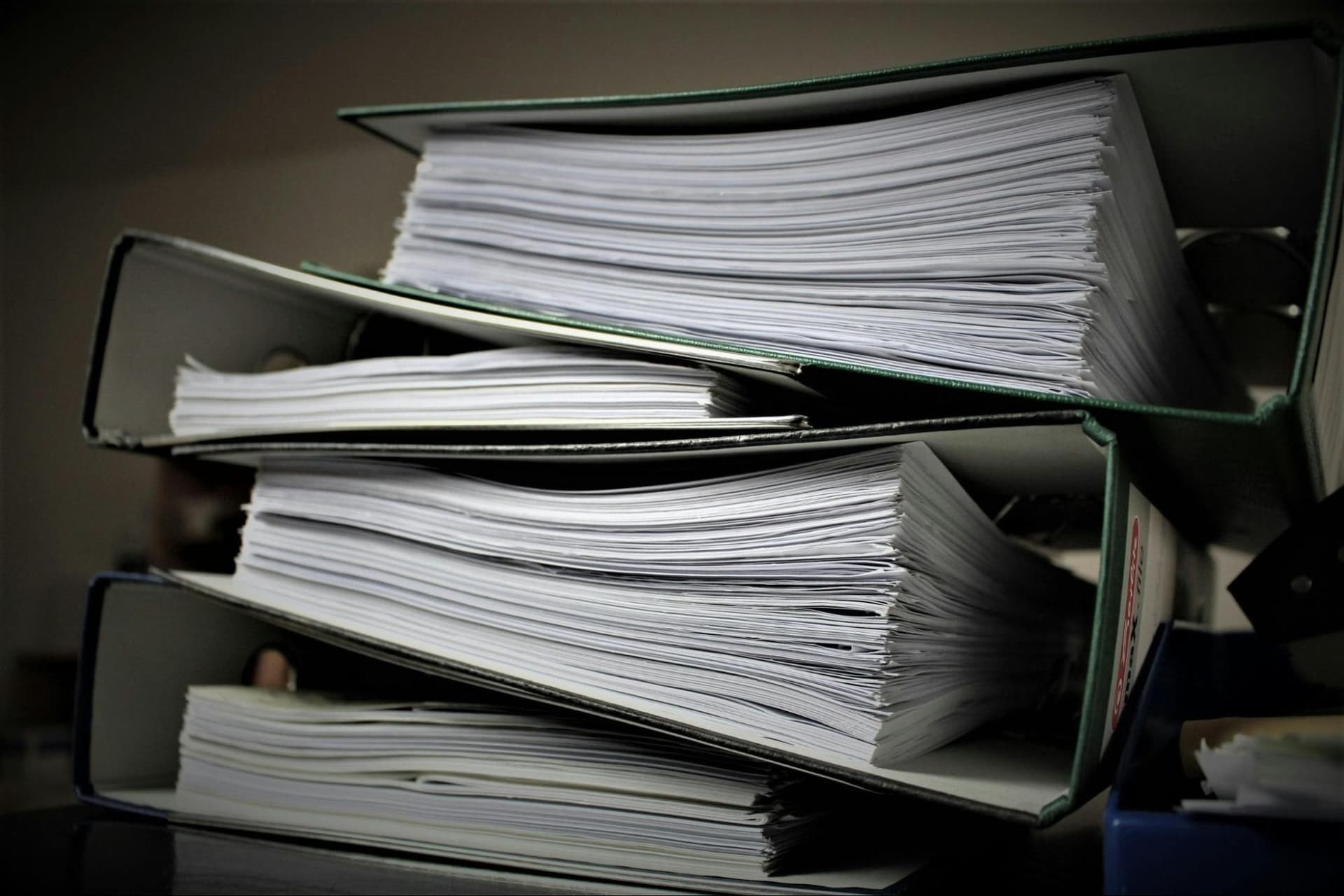 A stack of four administrative folders placed neatly on top of one another