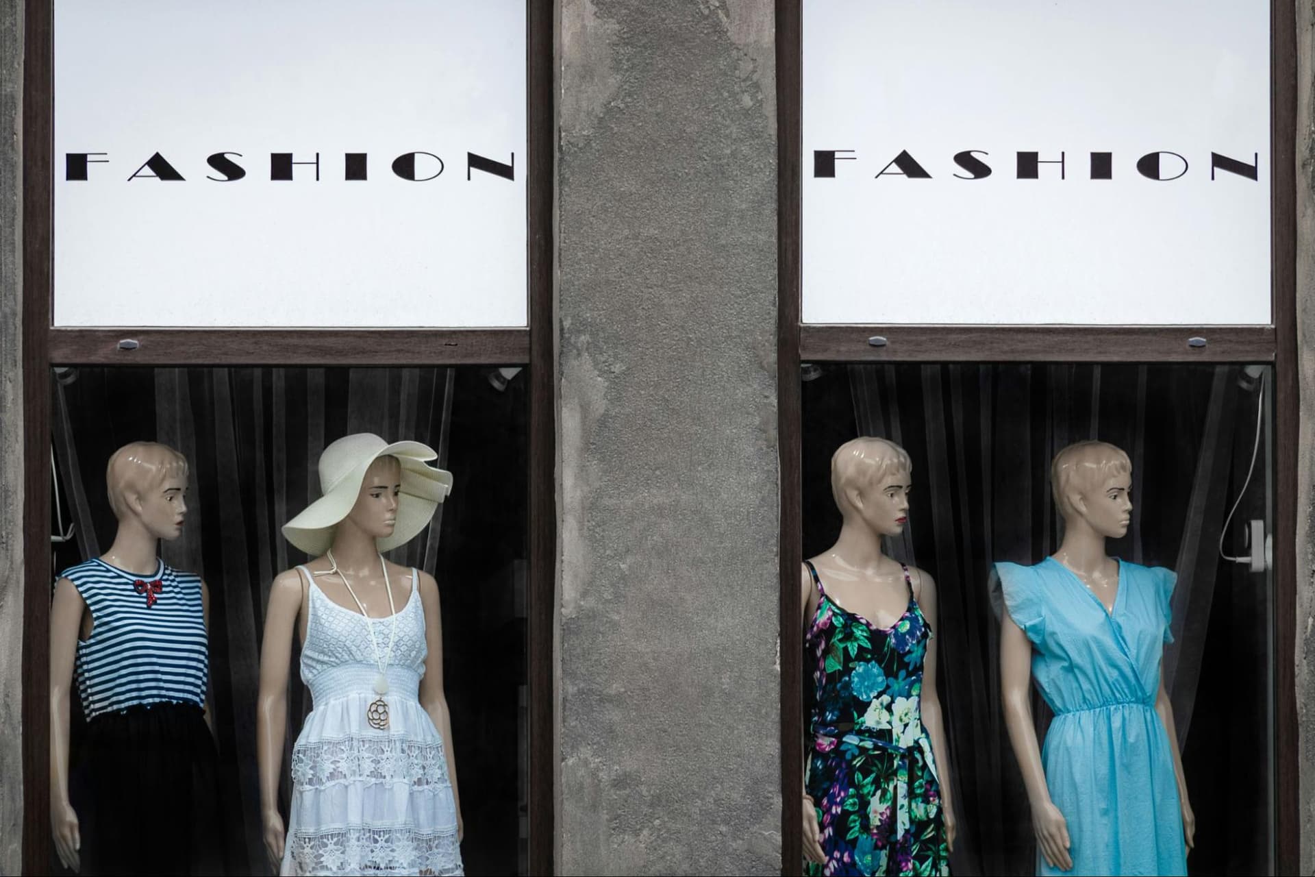 A store window display featuring four mannequins dressed in fashionable clothing