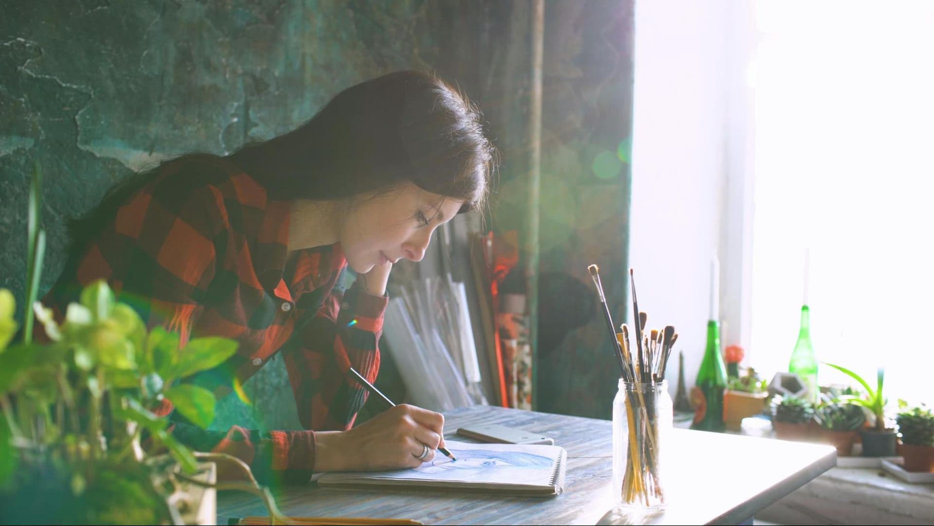 A woman sitting at a desk and painting