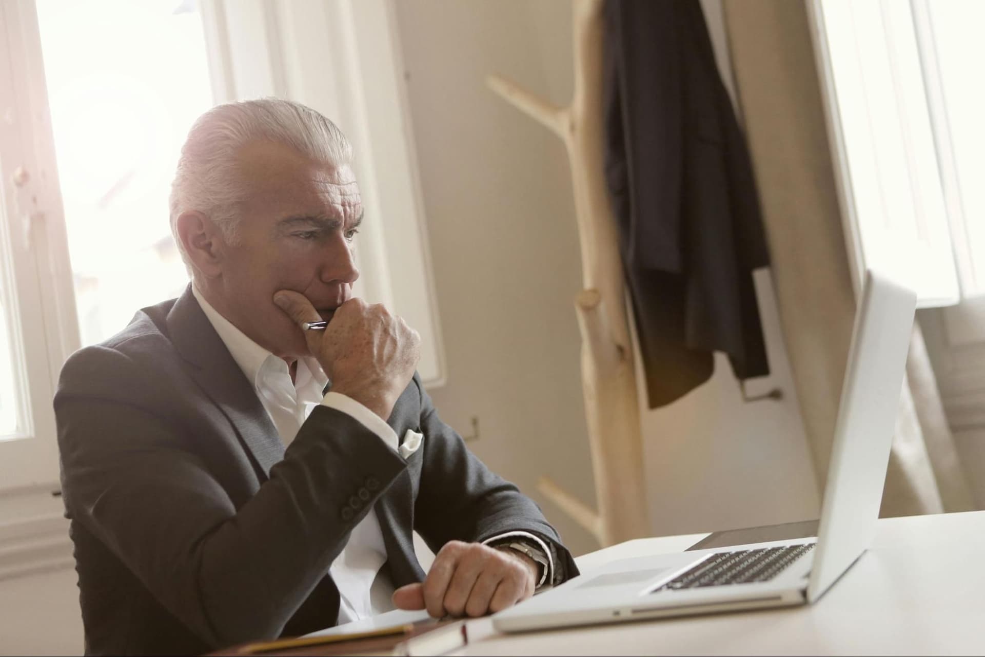 A man engaged in deep thought working on a laptop