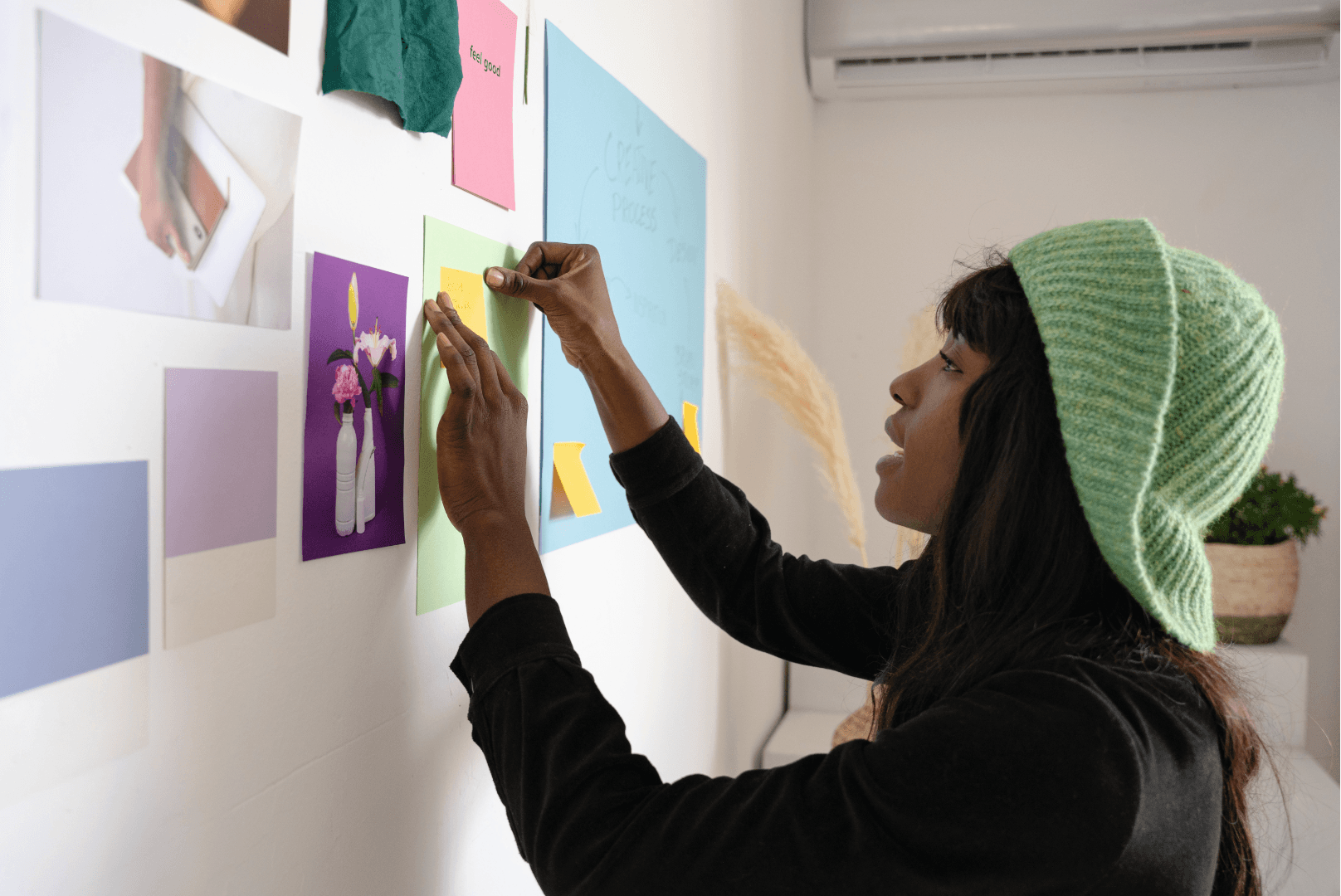 A young woman hanging artwork on a wall
