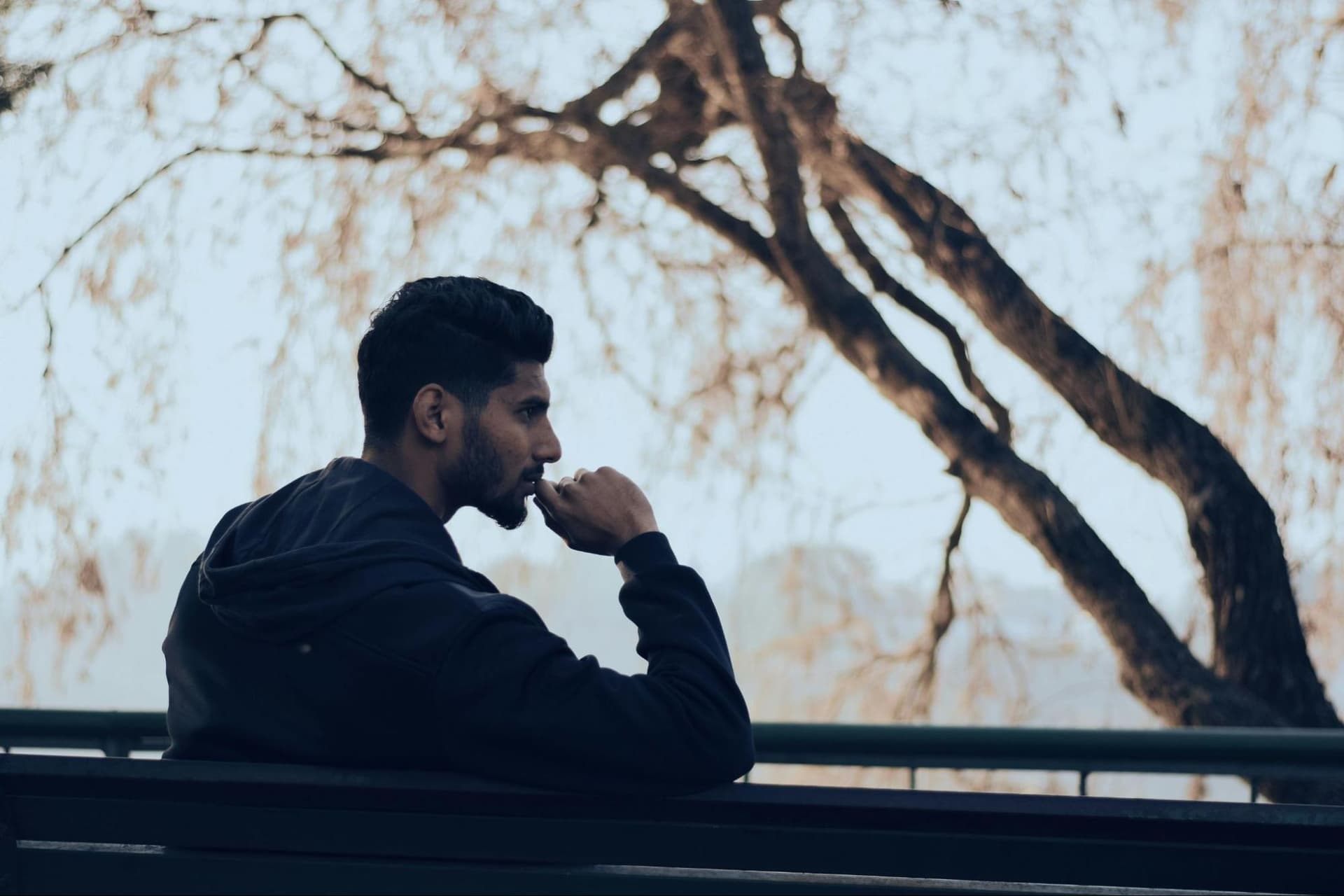 A man sitting on a bench, engaged in thought
