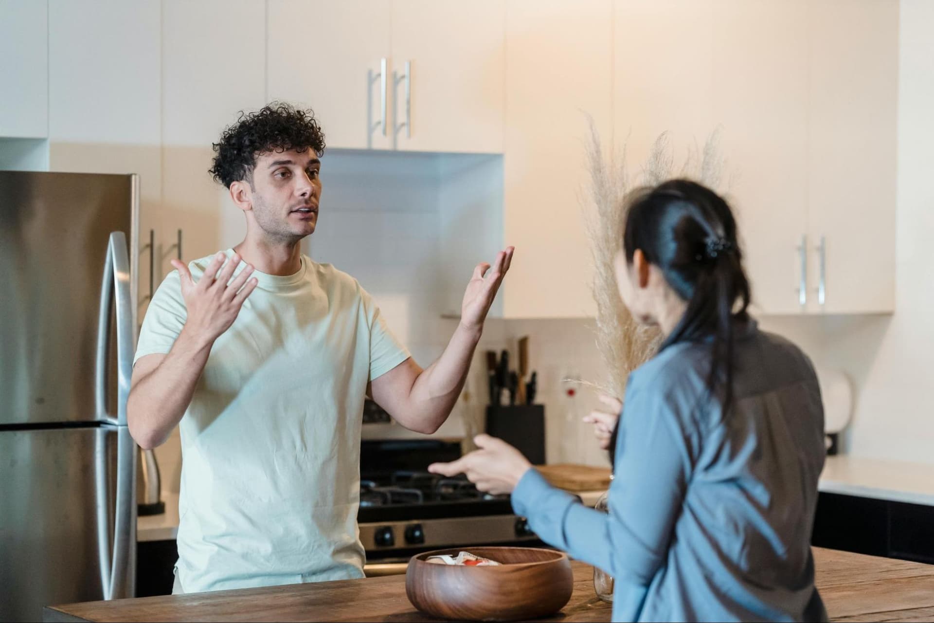 A man and a woman arguing in a kitchen